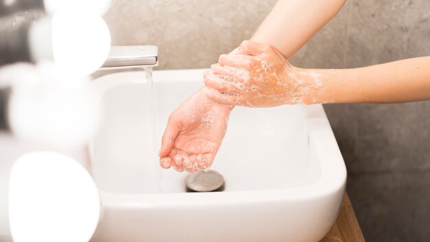 Persona lavarsi le mani con sapone