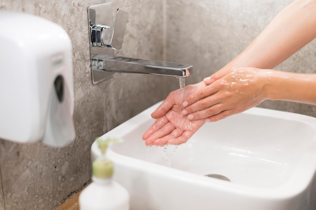 Persona lavarsi le mani con sapone