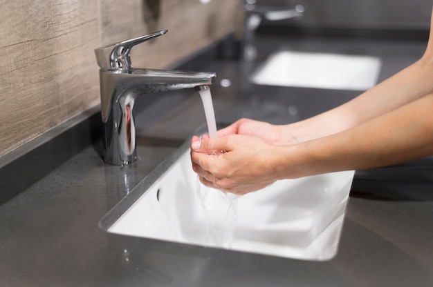 Persona lavarsi le mani con sapone