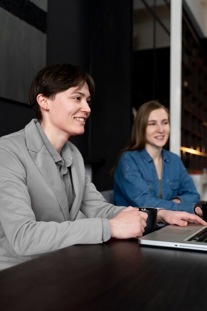 Persona trans che lavora in ufficio con i colleghi