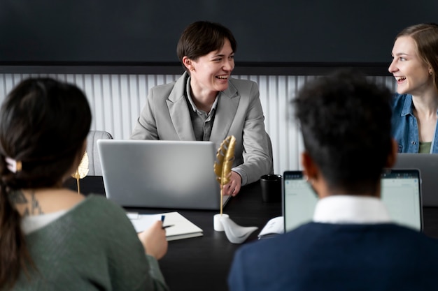 Persona trans che lavora in ufficio con i colleghi