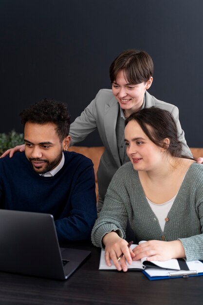 Persona trans che lavora in ufficio con i colleghi