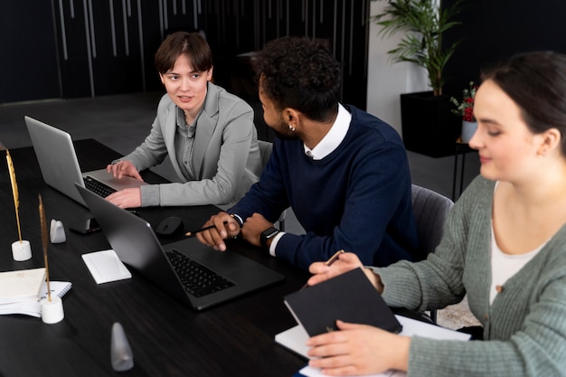 Persona trans che lavora in ufficio con i colleghi