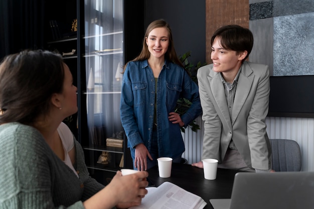 Persona trans che lavora in ufficio con i colleghi