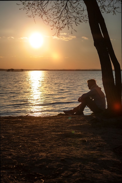 Persona triste e contemplativa vicino al lago