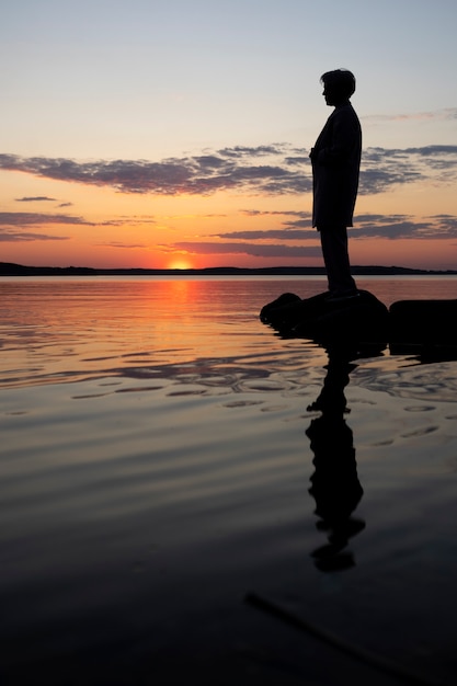 Persona triste e contemplativa vicino al lago