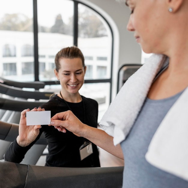 Personal trainer femminile e il suo cliente in possesso di una carta