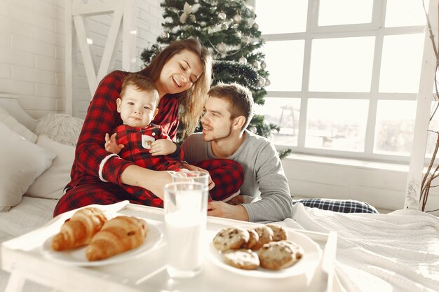 Persone a casa. Famiglia in pigiama. Latte e croissant su un vassoio.