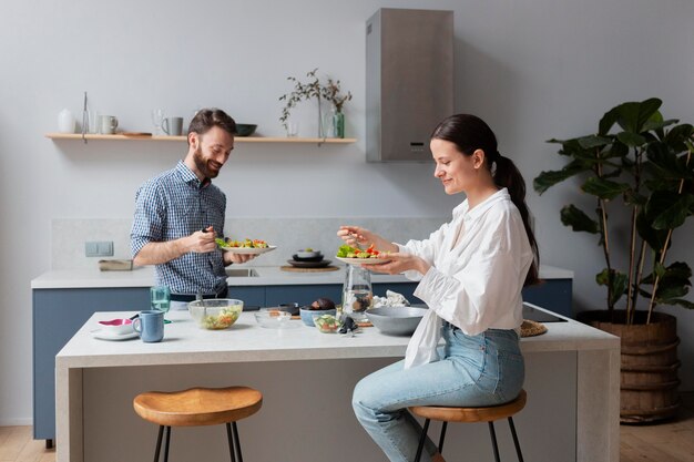 Persone a tiro medio che mangiano insalata