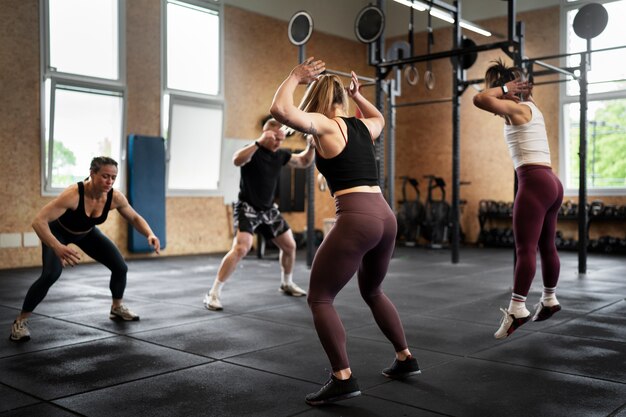 Persone a tutto campo che fanno i burpees insieme