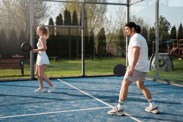 Persone a tutto campo che giocano a paddle tennis