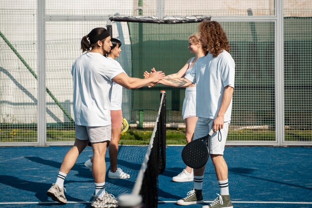 Persone a tutto campo che giocano a paddle tennis