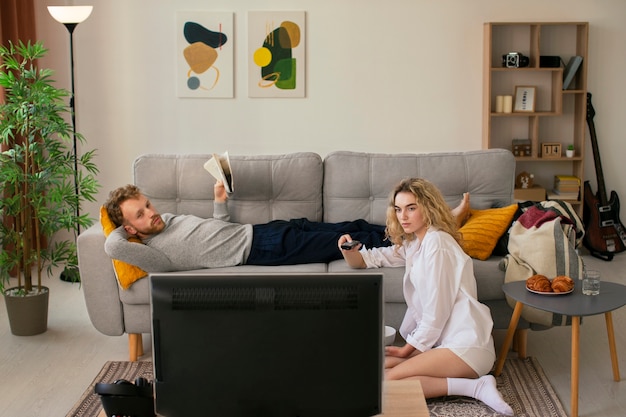 Persone a tutto campo che guardano la tv in soggiorno