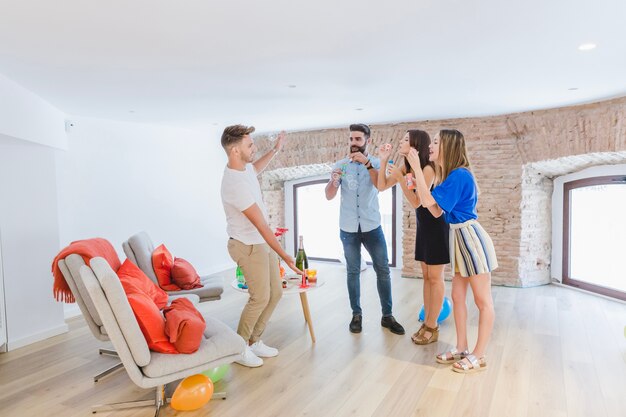 Persone al partito che giocano con bolle di sapone