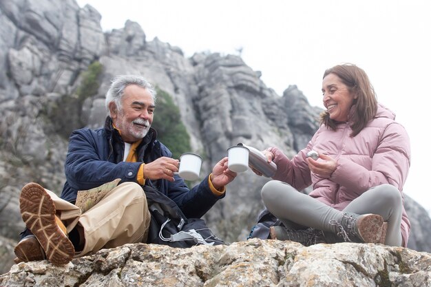 Persone anziane a tutto campo che bevono caffè all'aperto