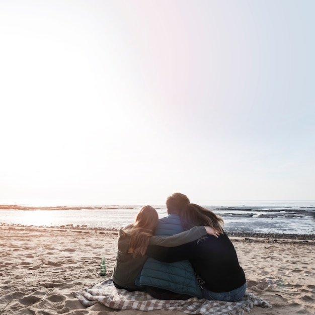 Persone che abbracciano e guardano il mare