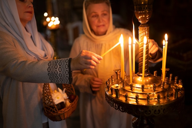 Persone che accendono candele in chiesa per celebrare la pasqua greca