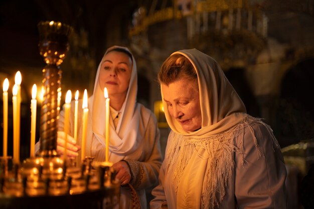 Persone che accendono candele in chiesa per celebrare la pasqua greca