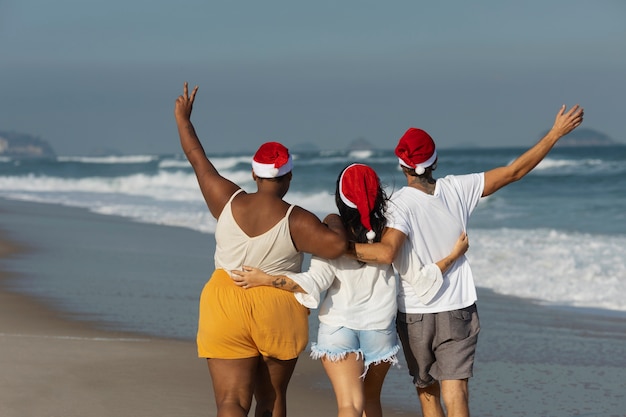 Persone che camminano sulla spiaggia vista posteriore