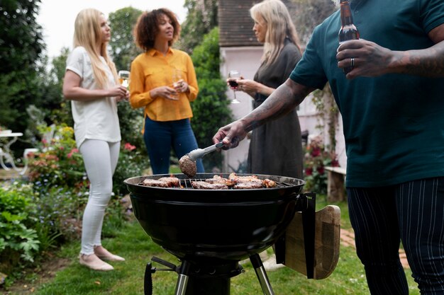 Persone che fanno barbecue insieme vista laterale