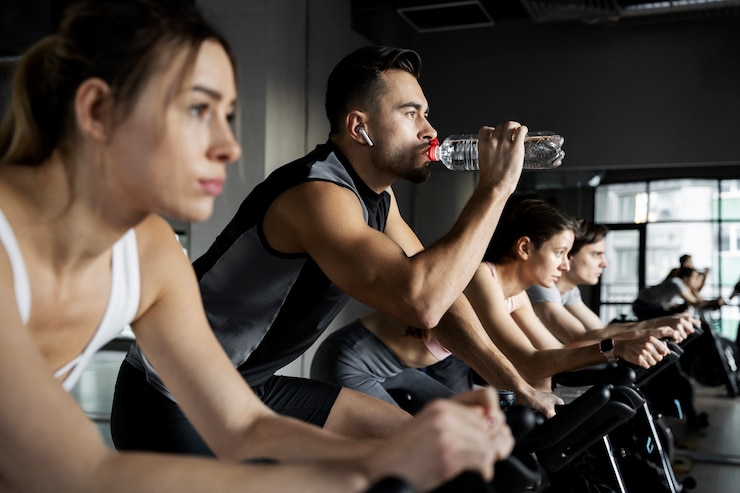 Foto gratuito persone che fanno ciclismo indoor