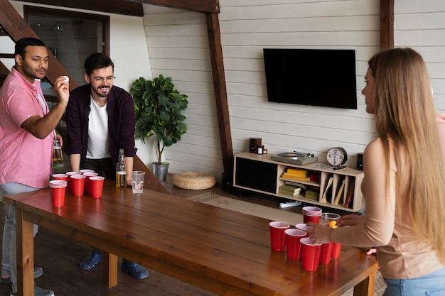 Persone che giocano a beer pong a una festa al coperto