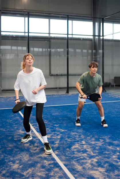 Persone che giocano a paddle tennis all'interno