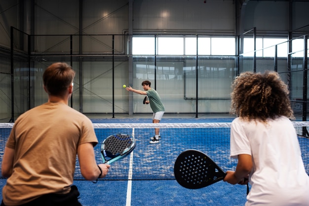 Persone che giocano a paddle tennis all'interno