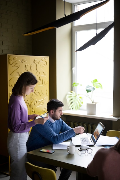 Persone che lavorano insieme al colpo medio dell'ufficio