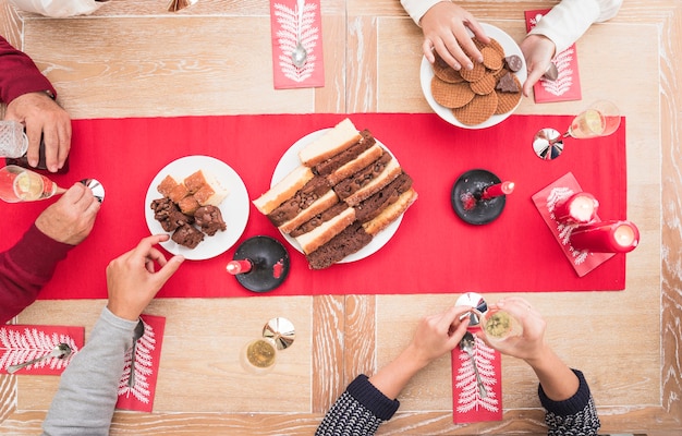 Persone che mangiano dessert al tavolo di Natale