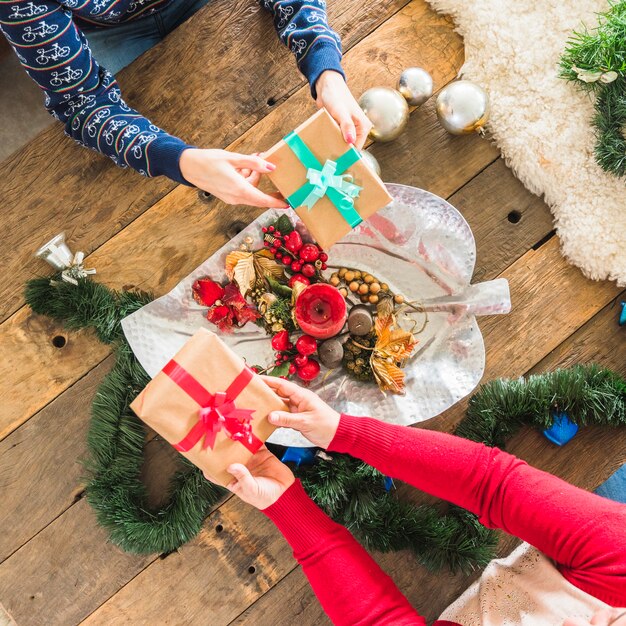 Persone che presentano regali a tavola decorata per Natale