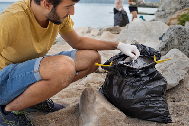 Persone che puliscono la spazzatura dalla natura