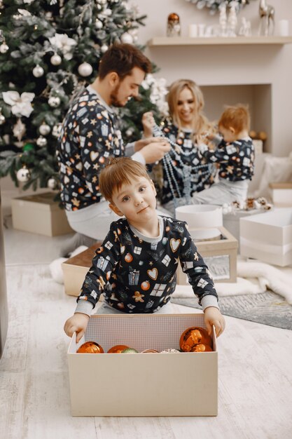 Persone che riparano per Natale. Persone che giocano con il bambino. La famiglia sta riposando in una stanza festiva.