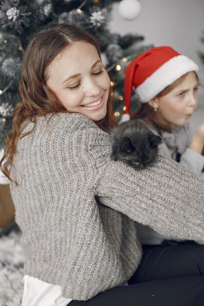 Persone che riparano per Natale. Persone sedute vicino all'albero di Natale.