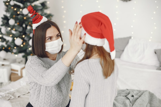 Persone che riparano per Natale. Tema Coronavirus. Madre che gioca con sua figlia. Bambino in un maglione grigio.