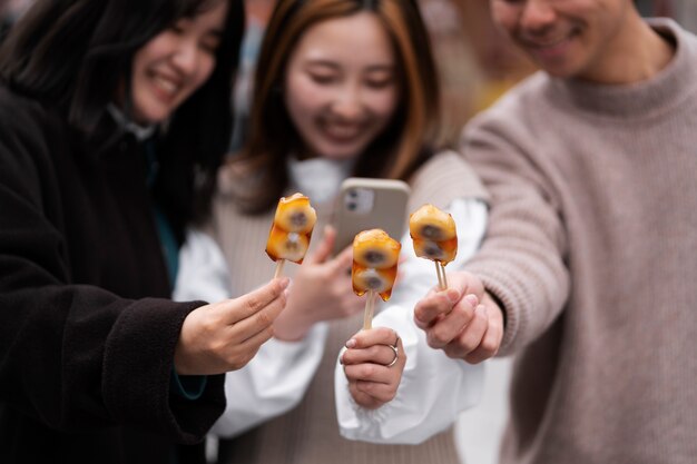 Persone che si godono il cibo di strada giapponese