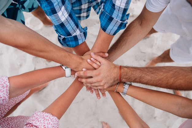 Persone che si uniscono le mani, gruppo di amici che tengono le mani insieme.