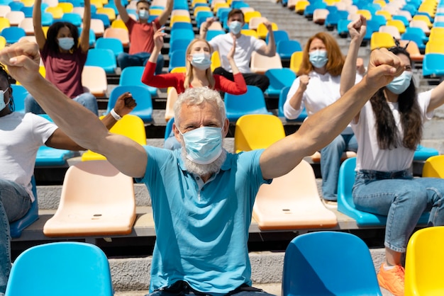 Persone con maschere mediche che guardano un gioco