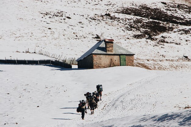 Persone con zaini che scalano la montagna in inverno