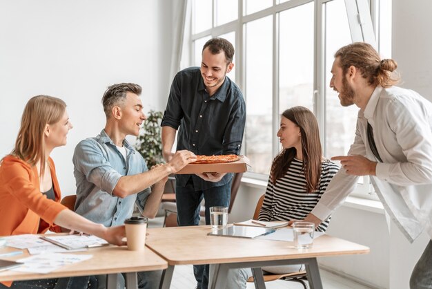 Persone di affari in pausa pranzo a mangiare la pizza