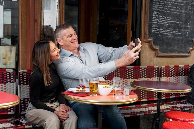 Persone di smiley colpo medio che prendono selfie