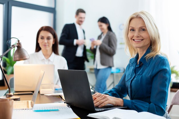 Persone di tiro medio che chattano al lavoro