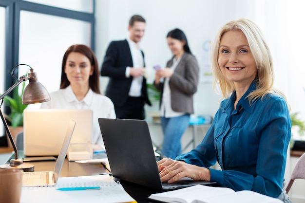 Persone di tiro medio che chattano al lavoro