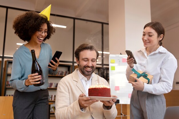 Persone di tiro medio che festeggiano con la torta