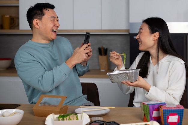 Persone di tiro medio che mangiano cibo asiatico