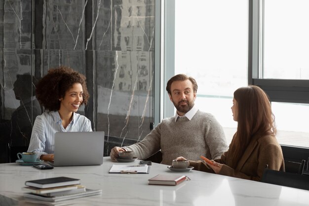 Persone di tiro medio che parlano al lavoro