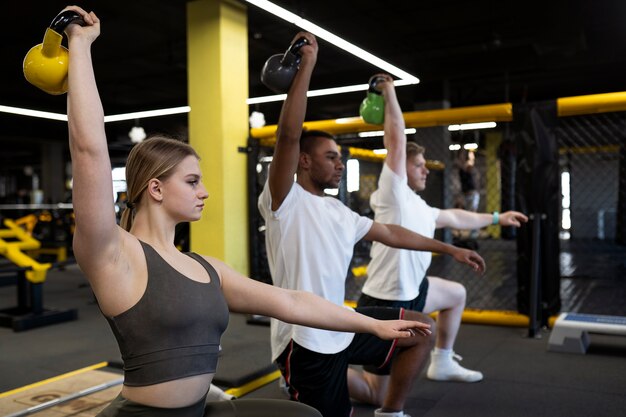 Persone di tiro medio che si esercitano con i kettlebell