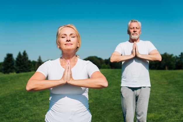 Persone di tiro medio meditando all'aperto