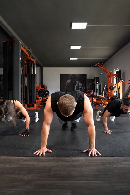 Persone di vista frontale che fanno insieme i burpees