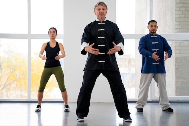 Persone di vista frontale che praticano il tai chi